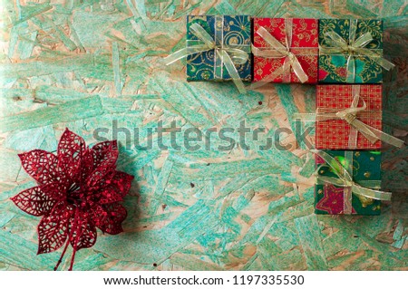 Orange colored christmas boxes on green wooden table,