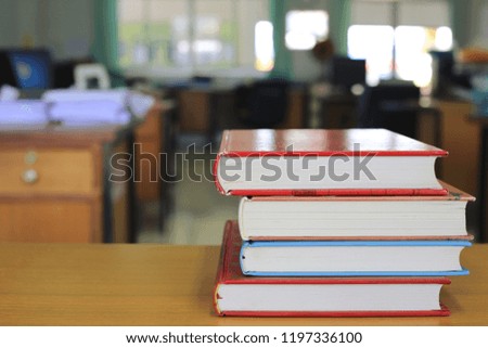 Close-up of several books stacked on a desk in an office selective focus and shallow depth of field