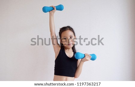 Little cute girl holding blue dumbbell,exercise concept