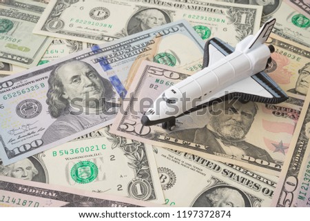Space shuttle on US dollar banknote background. An independent agency of the US federal government responsible for the civilian space program, aeronautics and aerospace research (NASA image not used)