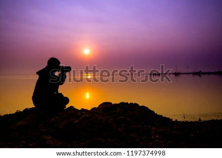 Abstract for photergrapher landscape background Silhouette of a landscape photographer or camera man in twilight with blurred nature blue sky  background at "Huai Luang Dam"  Udon thani,Thailand.