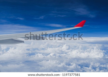 View from airplane window and the wing with fluffy clouds, flying and traveling concept background