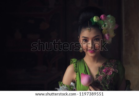 Asian fairy goddess adorned with lotus flowers, she was smiling beautifully on  wooden background.