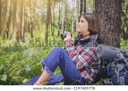 Beautiful girl learning to use film camera close to nature.