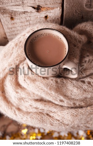 Details of still life in the home interior living room. Beautiful Cup of hot cocoa or chocolate and sweaters on wooden background . Cosy autumn-winter concept