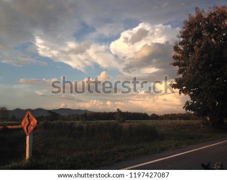 Road sign when sunset and cloud over a dark landscape.