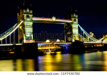 A long exposure photo of Tower Bridge during at night with illuminating light at night.