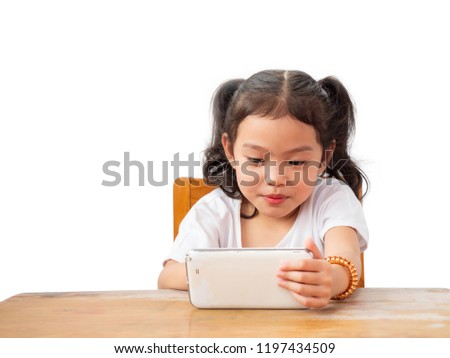 Little cute girl sitting on chair and happy to use smartphone.On white backdrop.