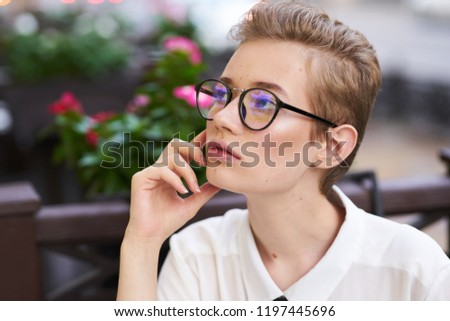 woman in shirt and glasses looks away                             