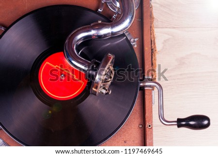 Retro styled image of a collection of old vinyl record lp's with sleeves. Browsing through vinyl records collection. Music background. Copy space. Old gramophone player with vinyl record. op view.