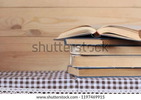 stack of books and one open book on the table. Empty space for Your text. Library, reading.