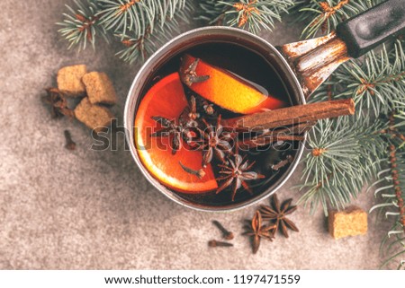 Hot mulled wine in a small vintage pan with christmas tree on the gray slate background. Christmas or winter warming drink. Top view. Copy space