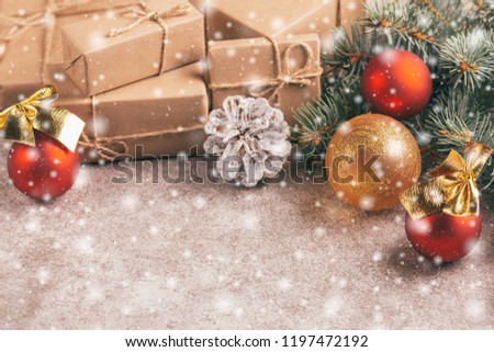 Craft gift boxes and Christmas decoration - Christmas tree branches and cones on slate marble background with snow effect. Horizontal view. Copy space.