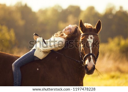 Young girl is resting on the horse back