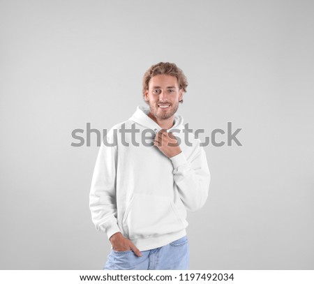 Portrait of man in hoodie sweater on light background. Space for design