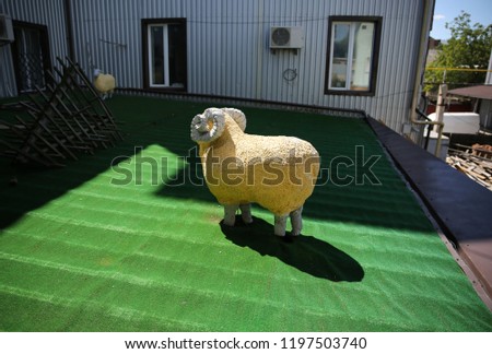Cute artificial sheep outdoors. Mockup of animal. Decoration for the yard.