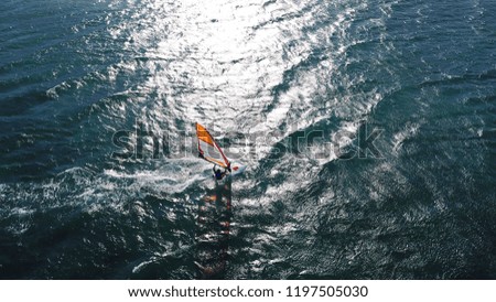 Aerial drone photo of surfer cruising in high speed in open sea wavy tropical ocean