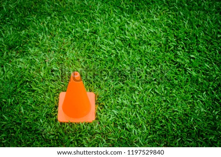 The orange plastic is located on the lawn. Symbolize is Be careful.