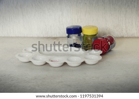 artist palette and poster color botlles on wooden floor.