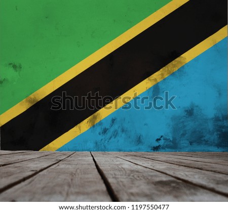 The floor of planks and plastered wall with a painted  Tanzania  flag.