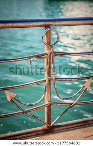 Novorossiysk, Russia. Decorative anchor on parapet of embankment to Tsemesskaya bay on the sea waves background