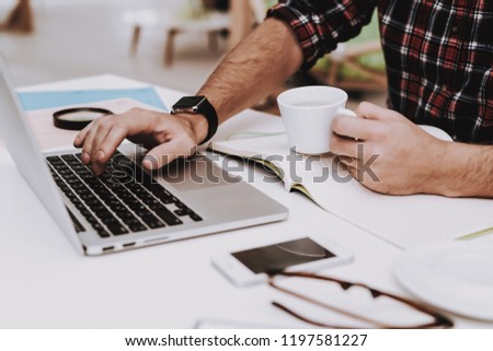 Laptop. Cup of Coffee. Desk. Workplace. Mobile Phone. Young Male. Businessman. Creative Worker. Creates Ideas. Project. Sit. Brainstorm. Work. Office. Creative Worker. Businesspeople. Inspiration.