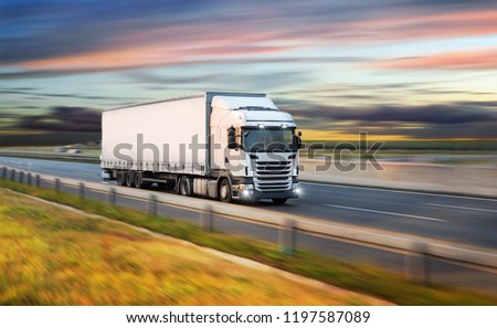 Truck with container on highway, cargo transportation concept. Shaving effect. Royalty-Free Stock Photo #1197587089