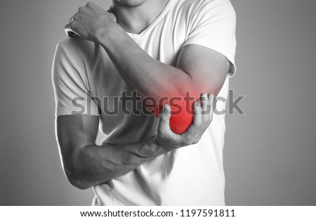 A man holding hands. Pain in the elbow. The hearth is highlighted in red. Close up. Isolated background. Royalty-Free Stock Photo #1197591811