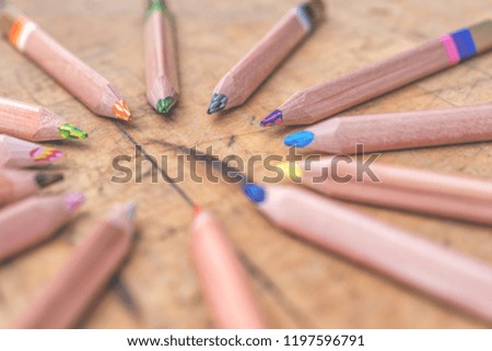 Three color pencils at old wooden surface
