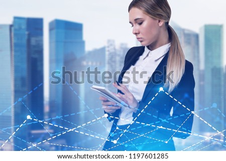 Serious blonde businesswoman writing in her notebook. Cityscape background. Bar chart and diagram in the foreground. Stock market concept. Toned image double exposure