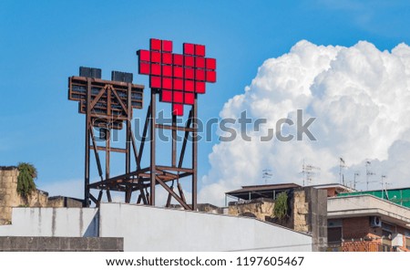 A picture of a pixelated heart at the top of a building, in Naples.