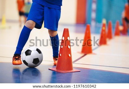 Indoor soccer players training with balls. Indoor soccer sports hall. Indoor football futsal player, ball, futsal floor and red cone. Futsal training dribbling drill. Sports background. Futsal league. Royalty-Free Stock Photo #1197610342