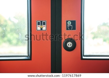 Close-up. The exit door of the train with a button to automatically open the door on demand when the train stops.