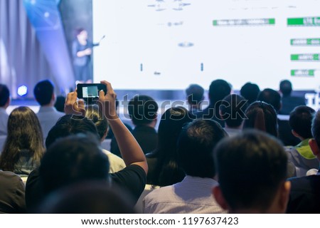 Attendees use smartphone photography in the seminar room