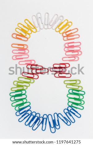 Number eight made from color paper clips, rainbow pattern, on white background, top view, isolated