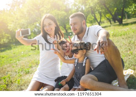Cheerful family doing selfie outdoors