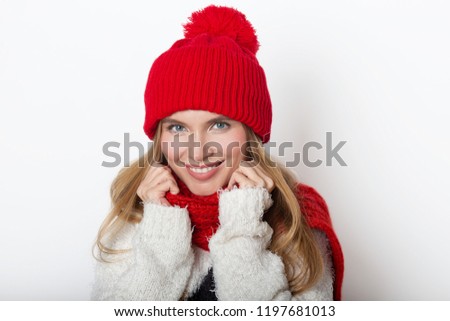 Beautiful winter portrait with young smiling women in red  woolen hat and scarf.