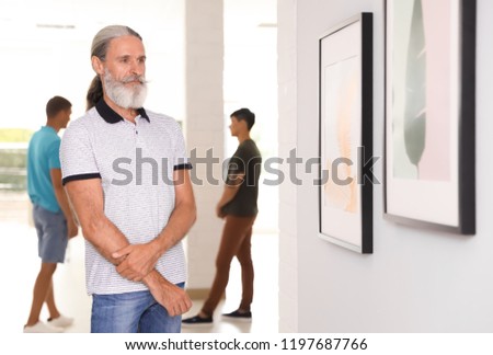 Senior man at exhibition in art gallery