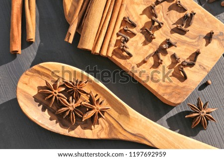 Christmas spices on wooden background. Food ingredients: star anise, cloves, and cinnamon sticks.