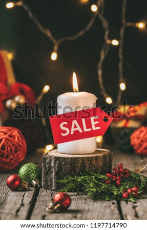 christmas candle with red sale tag on wooden stump