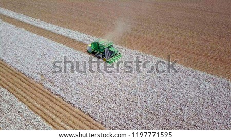 Aerial image of a six row Baler Cotton picker working in a field. Royalty-Free Stock Photo #1197771595