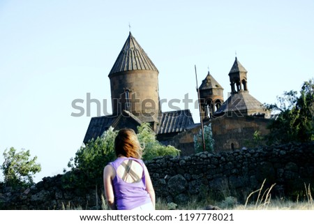 Beautiful girl standing with her back against a beautiful background.Saghmosavank Medieval monastery in the village of Saghmosavan in the Aragatsotn Province of Armenia.