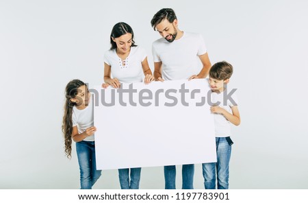 Big happy family with white blank board in hands for advertisement isolated on white