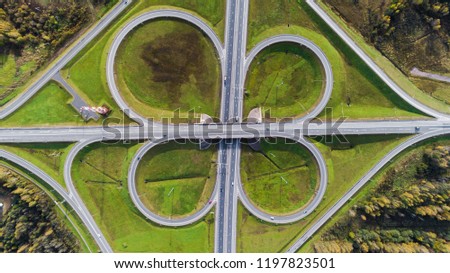 Aerial view of highway interchange  Road junction Aerial photo of a highway going through the forest