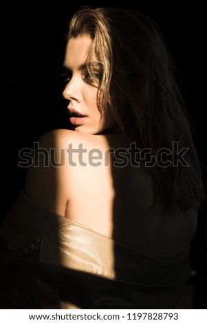 side view of beautiful and stylish model looking at camera