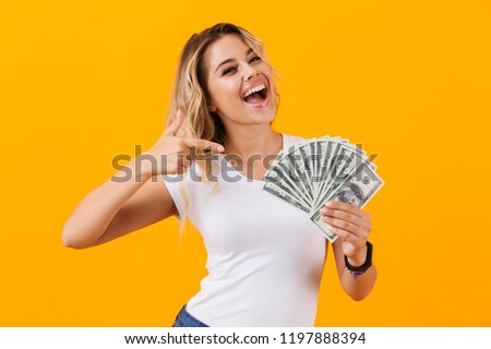Photo of rich woman in basic clothing holding fan of dollar money isolated over yellow background