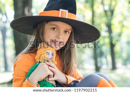 Child girl with pumpkin outdoors in halloween