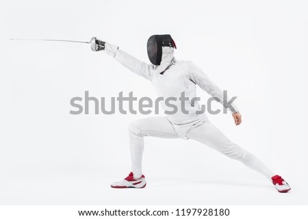 Young fencer athlete wearing mask and white fencing costume. holding the sword. Isolated on white background Royalty-Free Stock Photo #1197928180