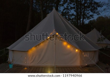 Illuminated glamping bell tent at night Royalty-Free Stock Photo #1197940966