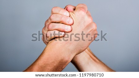 Man hand. Two men arm wrestling. Arms wrestling. Closep up. Friendly handshake, friends greeting, teamwork, friendship. Hand, rivalry, vs, challenge, strength comparison.